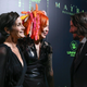 Carrie-Anne Moss in a plunging black dress, Lana Wachowku with orange/pink-yellow hair, and Keanue Reeves in a normal suit.
